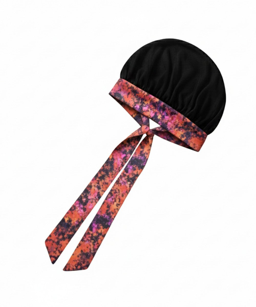 Flat lay of a Lew's Collections satin hair bonnet, featuring a vibrant black mesh lattice cap and a multicolored 'Cloudy Blossom' adjustable satin tie band with a knot.