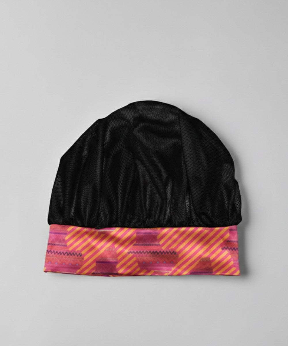Flat lay of a Lew's Collections satin hair bonnet, featuring a classic black mesh lattice cap and a multicolored 'Aztec Afrique' satin band.