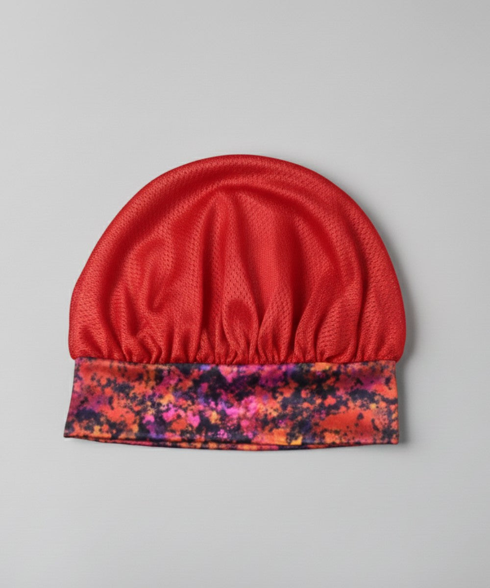 Flat lay of a Lew's Collections satin hair bonnet, featuring a vibrant red mesh lattice cap and a multicolored 'Cloudy Blossom' satin band.