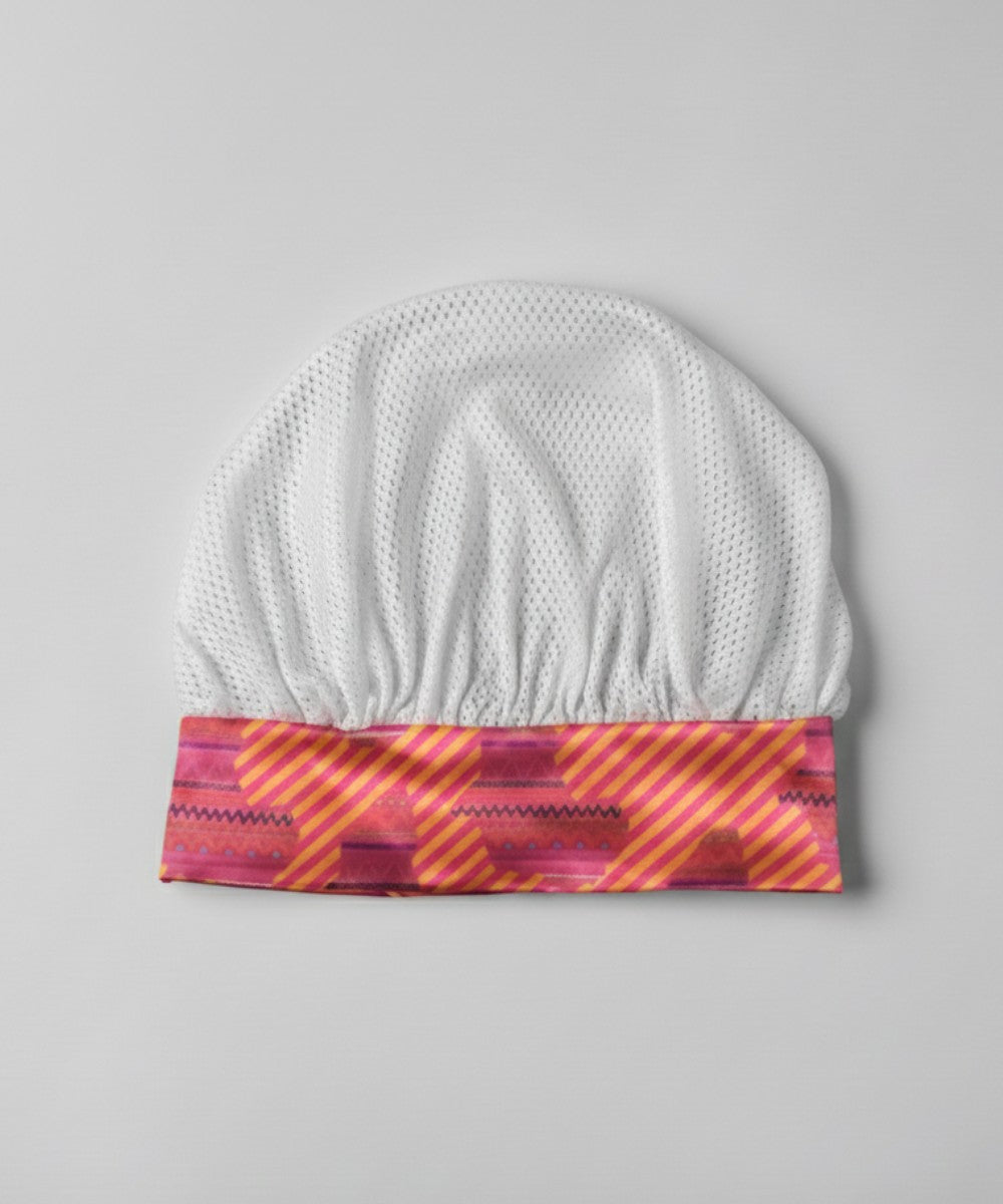 Flat lay of a Lew's Collections satin hair bonnet, featuring a cool white mesh lattice cap and a multicolored 'Aztec Afrique' satin band.