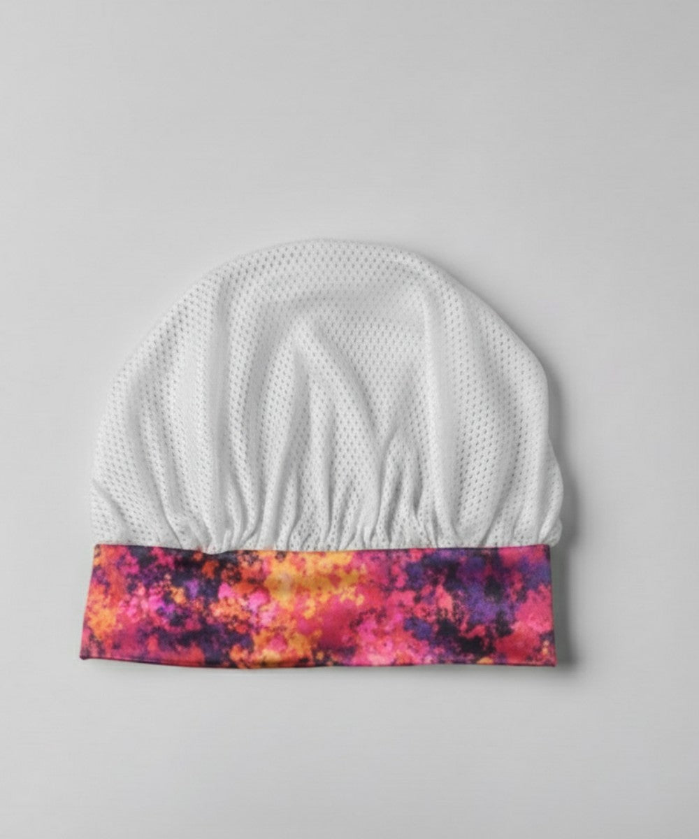 Flat lay of a Lew's Collections satin hair bonnet, featuring a cool white mesh lattice cap and a multicolored 'Cloudy Blossom' satin band.