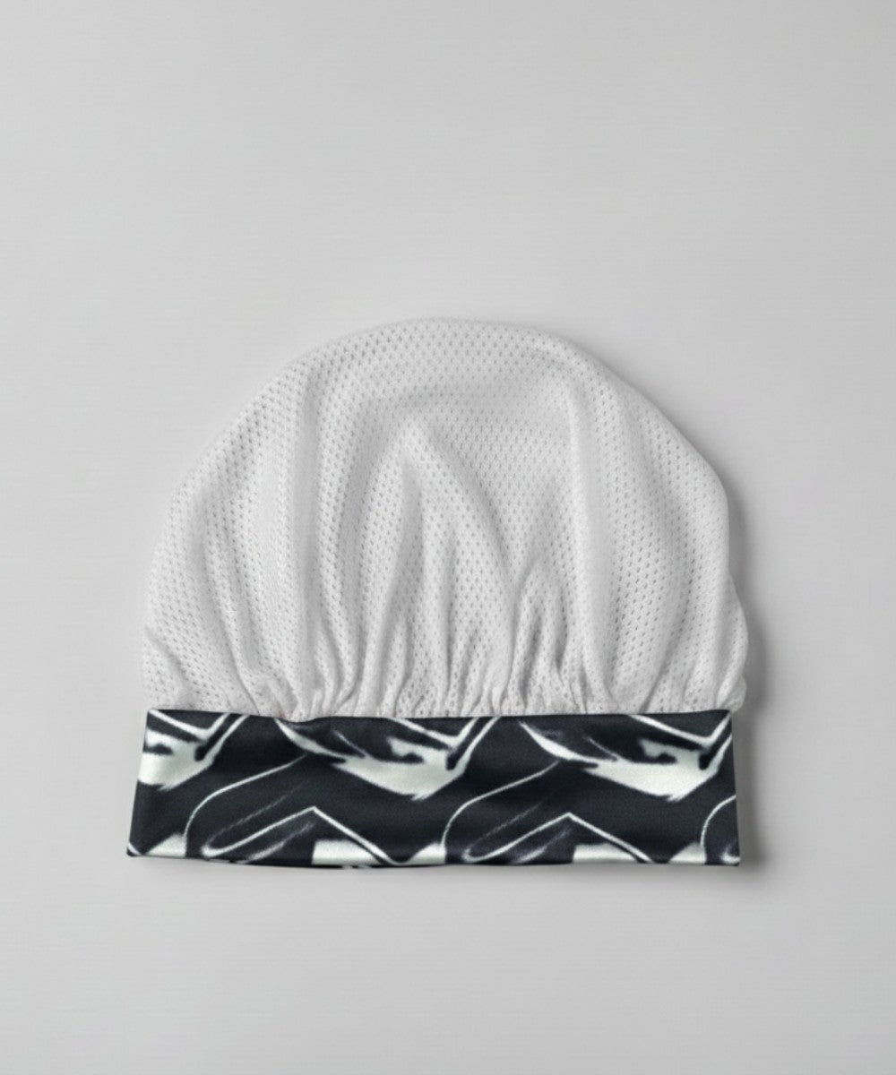 Flat lay of a Lew's Collections satin hair bonnet, featuring a cool white mesh lattice cap and a two tone 'Marble Noir' satin band.